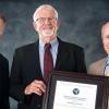Department Head, Dr. Bill Cooke (center) holding the Geospatial Center for Academic Excellence Award