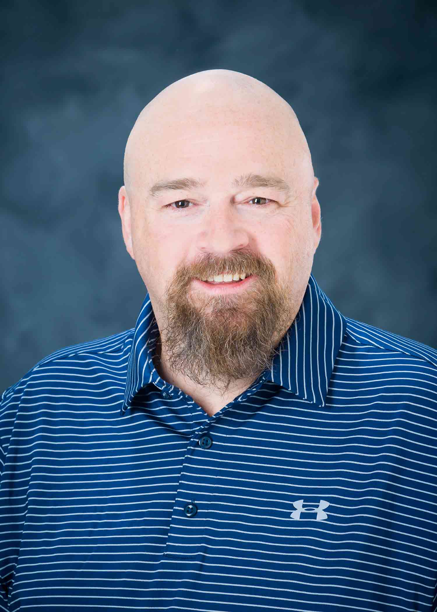 Professional photo of Mike Brown, wearing a blue shirt against a blue background.