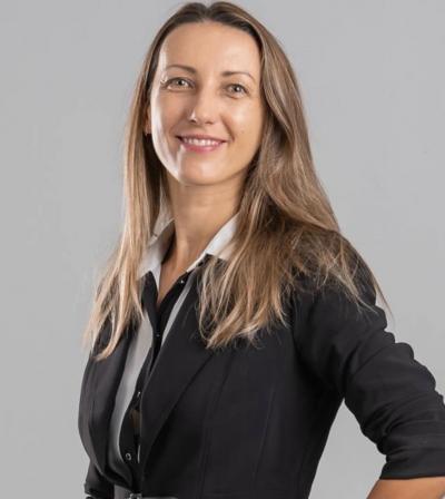 A headshot of Dr. Narcisa Pricope. She has brown long hair and is wearing professional clothes. 